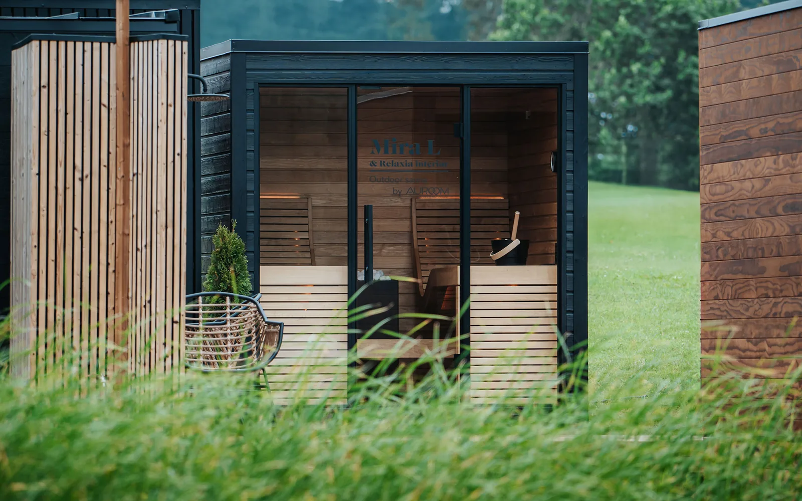 A glass garden sauna placed in a backyard
